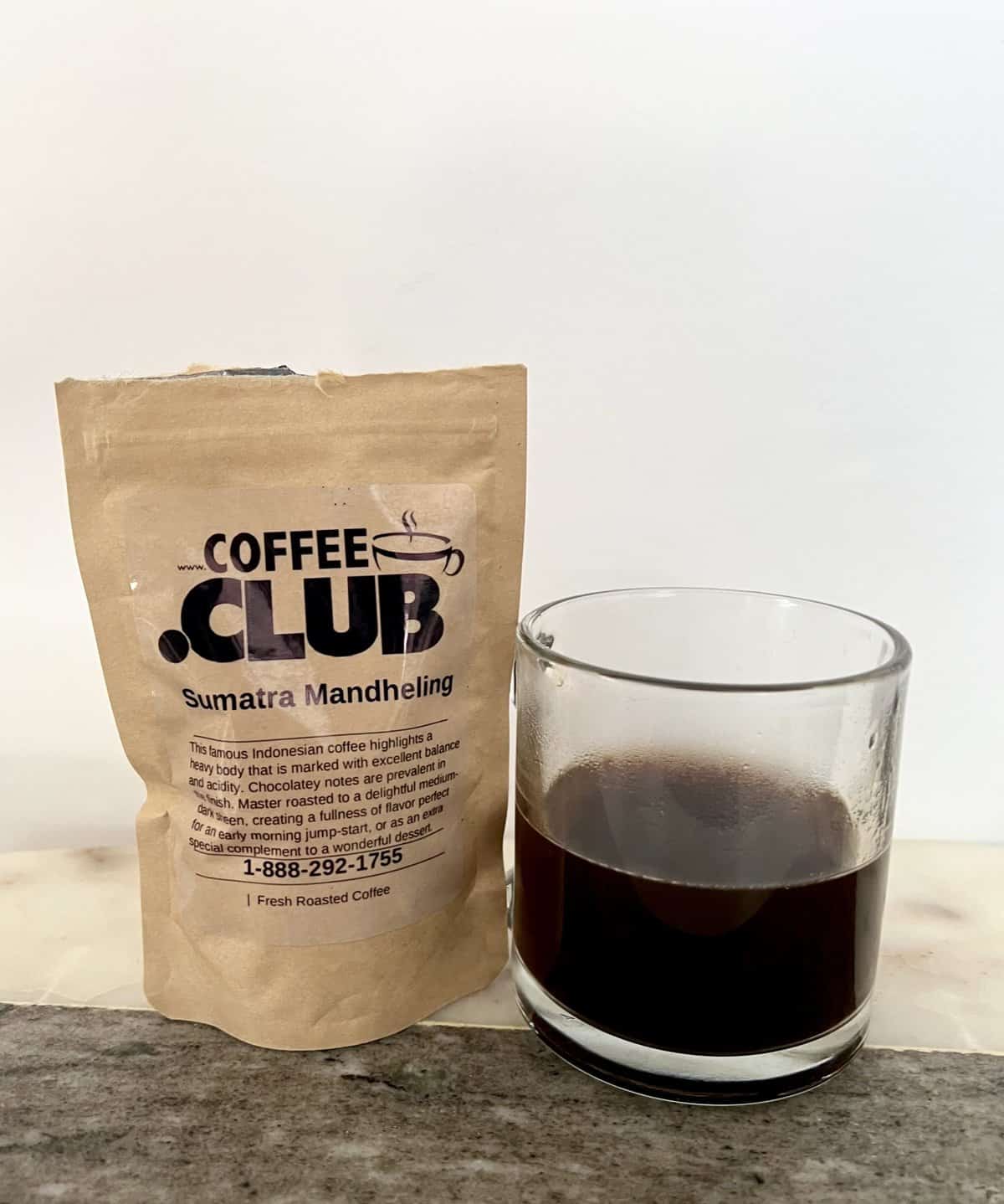 Sumatra-Mandheling-coffee-next-to-a-cup-of-brewed-coffee-scaled